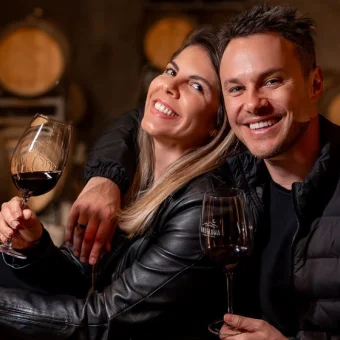 Halley e Ju brindando com vinho numa adega