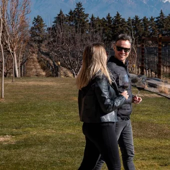 Halley e Ju caminhando pela vinícola com os Andes ao fundo