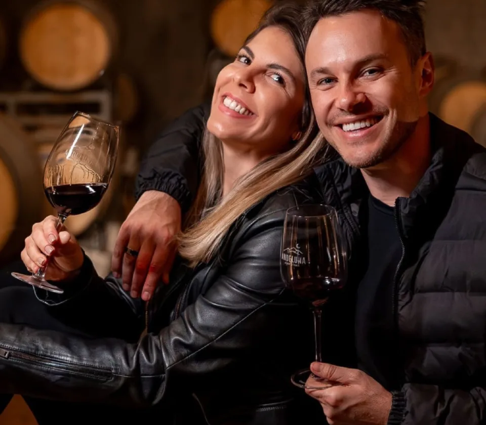 Halley e Ju brindando com vinho em uma adega em Mendoza